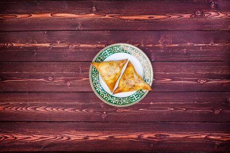 Plate with delicious samosas or samsa on wooden background. Top viewの写真素材