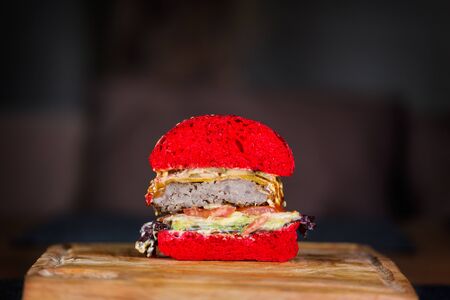 Red velvet Burger cutaway on a wooden board.の写真素材