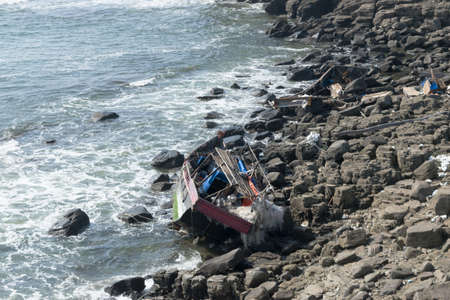 The wreckage of a boat crashed on the stones