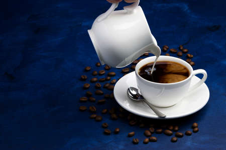 black coffee with milk on a deep blue backgroundの写真素材