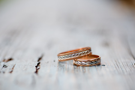 beautiful wedding rings on a light wooden background. bokeh close-up
