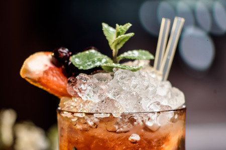 summer cocktail with ice decorated with mint and berries on a wooden table on a floral background. berry mojito. close up. spaceの写真素材