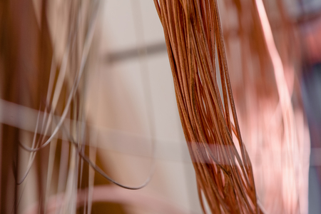 Red metal. Copper wire in production. Red wire close-up