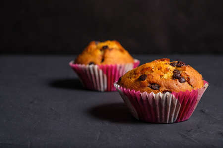Cupcake with pieces of chocolate on a dark background.の写真素材