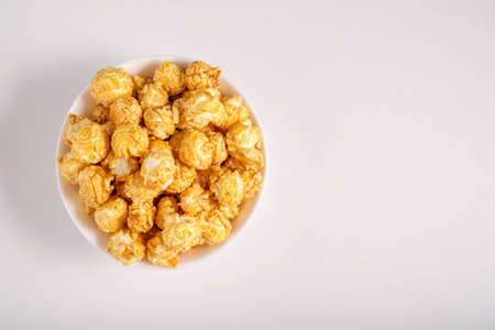 Popcorn on a white plate in a white plate. View from above