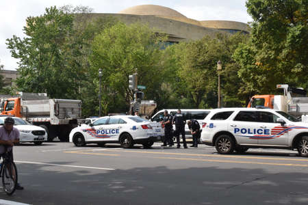 Washington, DC, USA - September 18, 2021: Police officer, police cars and municipal trucks at Third...