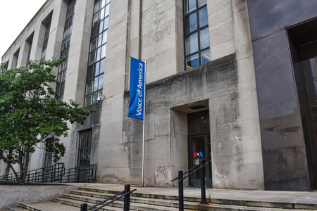 Washington, DC, USA - September 18, 2021: Entrance to the Wilbur J. Cohen Federal Building, Displaying a Blue Flag for the Voice of America Headquartersのeditorial素材