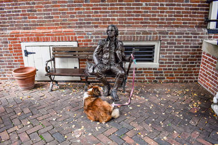 Alexandria, Virginia, USA - October 8, 2021: Statue of Charles Lee Sitting on a Bench in Old Town Alexandria Watches Over a Dogのeditorial素材