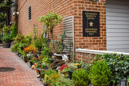 Alexandria, Virginia, USA - October 8, 2021: Garden in an Alleyway Next to the Garage Opening of the Alexandria Sheriffâs Office in Old Town Alexandriaのeditorial素材