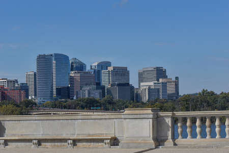 Arlington, Virginia, USA - October 25, 2021: Arlington Skyline as Seen from the Memorial Bridge on a Sunny Fall Afternoon with Bridgeâs Concrete Railing and a Bench in the Foregroundのeditorial素材