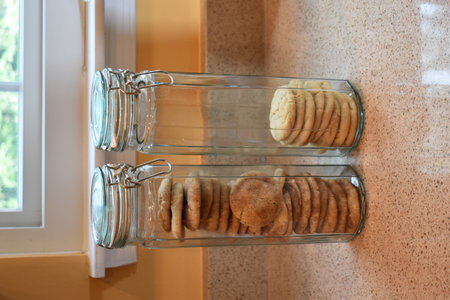 Cookies, stacked side by side, in two, tall, thin, glass cookie jarsの写真素材