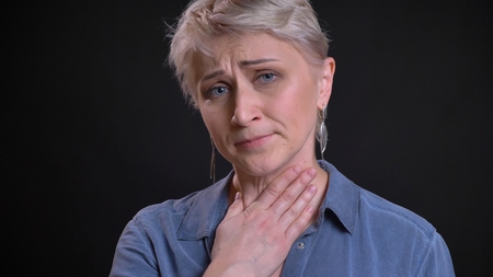 Closeup portrait of adult attractive caucasian female having a sick throat and being ill while...