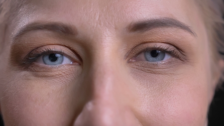 Closeup shoot of young attractive caucasian female with blue eyes looking straight at cameraの写真素材