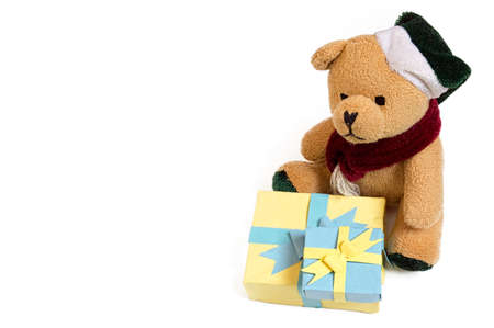 Cute small furry toy teddy bear sitting with two handmade paper gift boxes isolated on white background - background picture for wishing a happy birthday with birthday cards, or for valentines dayの写真素材