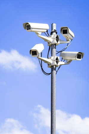 security cameras in front of blue sky - with space for textの写真素材