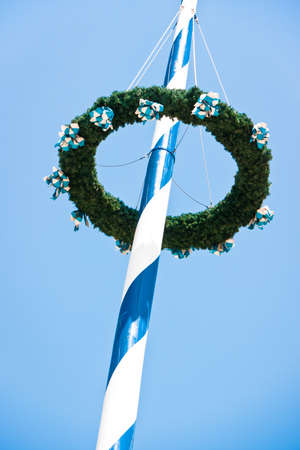 typical bavarian maypole in front of blue skyの写真素材