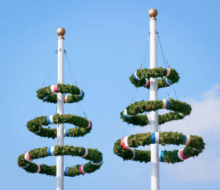 typical bavarian maypole in front of blue sky