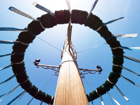 typical bavarian maypole in front of blue skyの写真素材