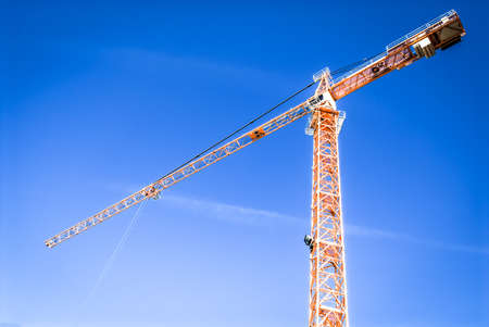 modern construction crane in front of blue skyの写真素材