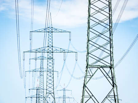 electricity pylons in front of blue sky
