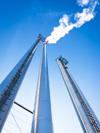 modern industry chimneys in front of blue skyのeditorial素材