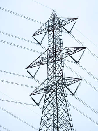 modern electricity pylon in front of blue skyの写真素材