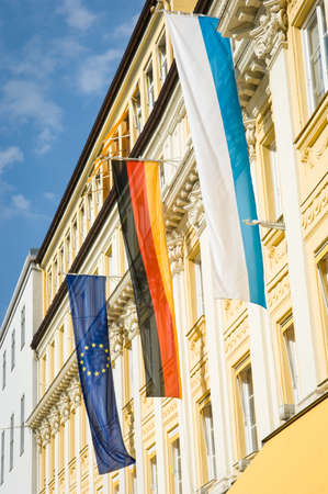flags of the european union and germany at a historic facadeの写真素材