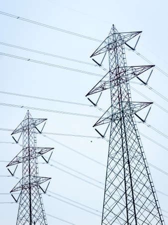 modern electricity pylon in front of blue skyの写真素材