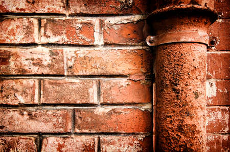 old brick wall and rusty tubeの写真素材