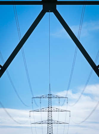 electricity pylons in front of blue skyの写真素材