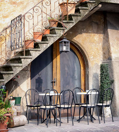 tables and chairs at a bistro in italyの写真素材