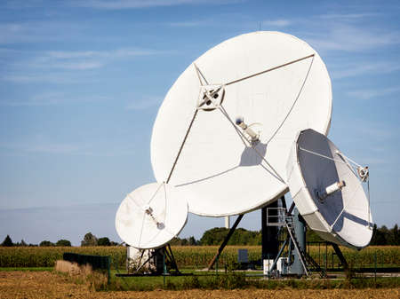 group of satelite dishes in front of blue sky