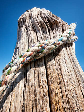 old wooden bollard and a rope