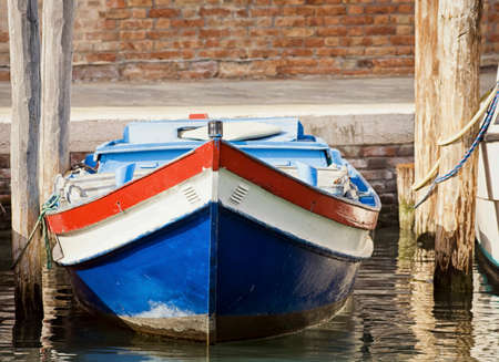 old wooden boat at a canal in veniceの写真素材
