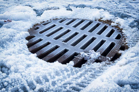 old manhole at a street in winterの写真素材
