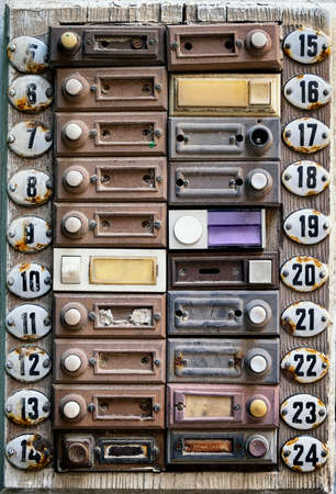 rundown old bell buttons at a wallの写真素材