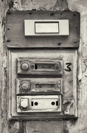 rundown old bell buttons at a wallの写真素材