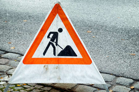 men at work sign at a road construction site