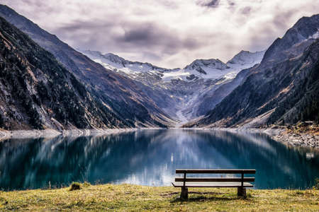 wooden bench at a reservoir in austriaの写真素材