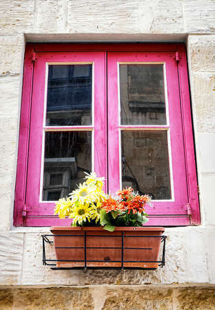 old window and flowers at a historic buildingの写真素材