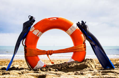 flippers and lifebelt at a beach