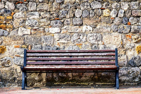old bench in front of a wallの写真素材