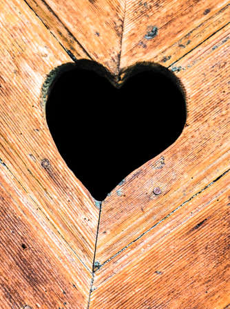 wooden heart at an antique restroom-doorの写真素材