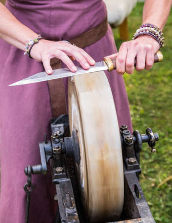 sharpening a knife with a whetstoneの写真素材