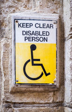 old disabled sign at a wallの写真素材