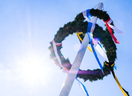 typical bavarian maypole in front of blue skyの写真素材