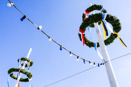 typical bavarian maypole in front of blue skyの写真素材