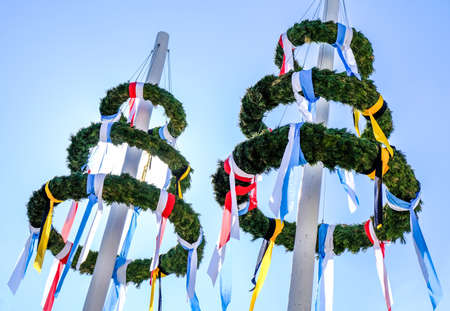 typical bavarian maypole in front of blue skyの写真素材