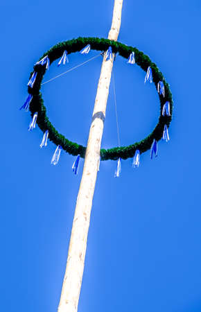 typical old bavarian maypole in front of blue skyの写真素材