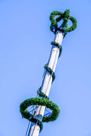 typical bavarian maypole in front of blue skyの写真素材